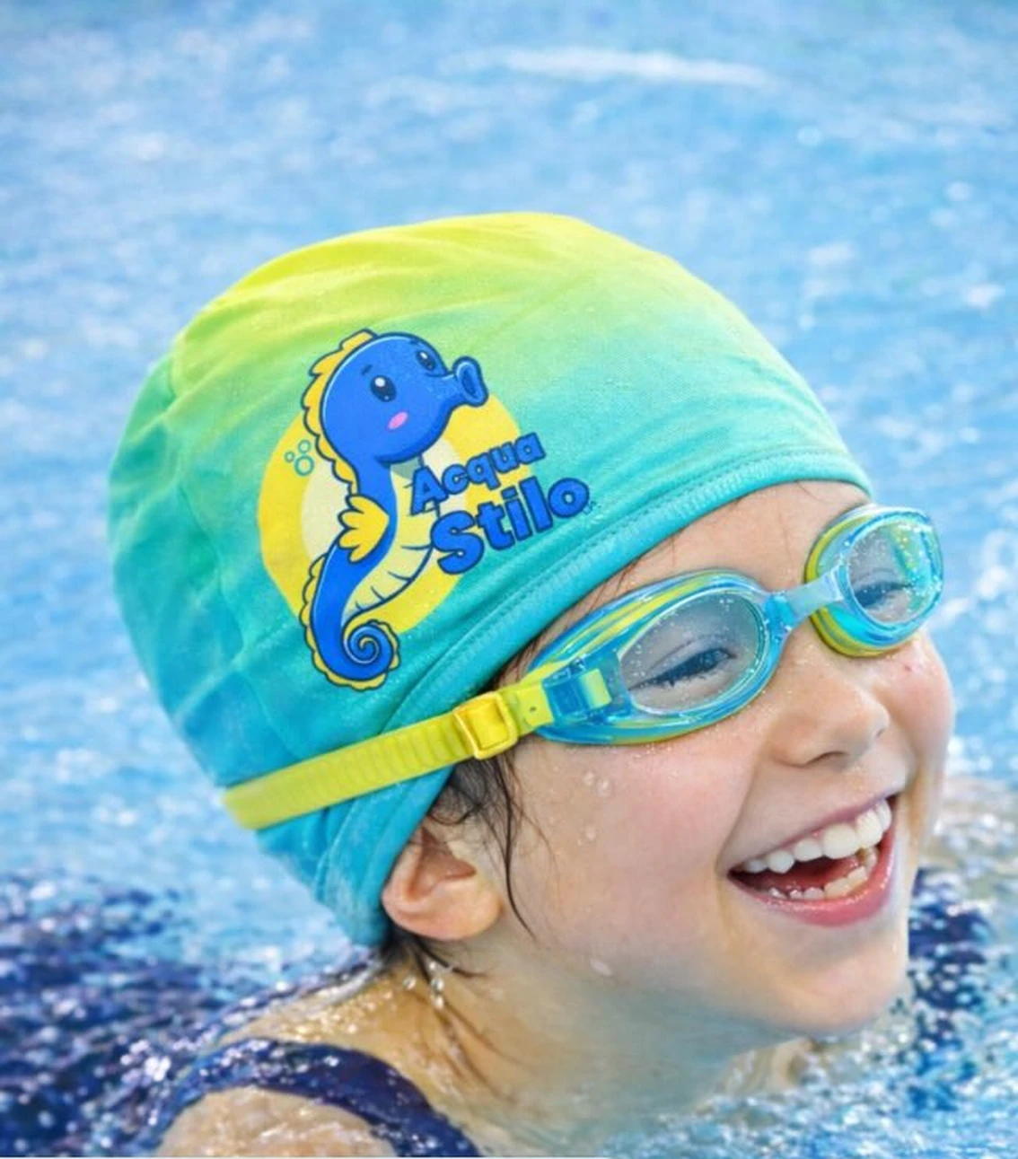 Criança sorrindo na piscina usando touca da Acqua Stilo