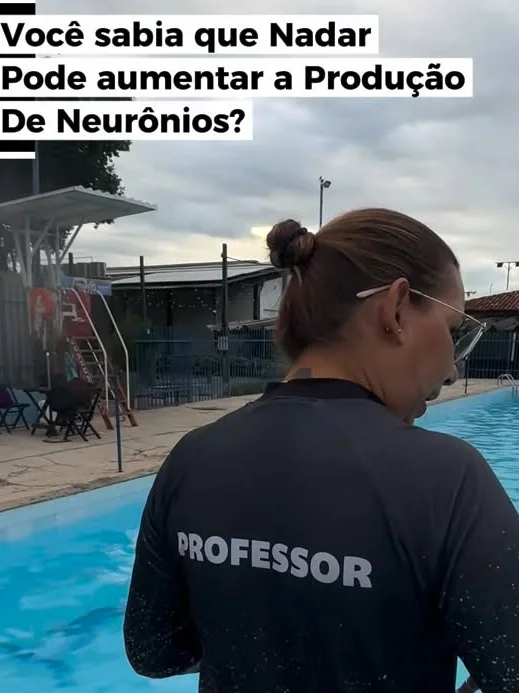 Professora na borda da piscina acompanhando os alunos