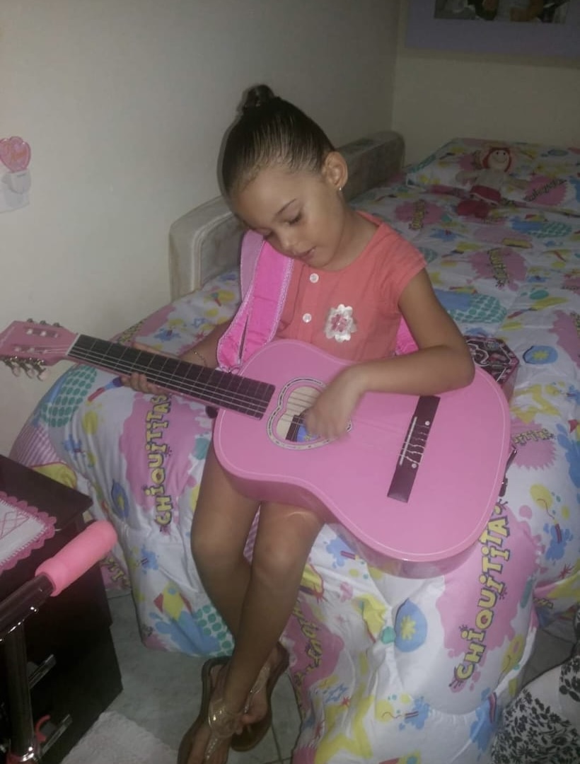 Melyssa criança tocando violão rosa
